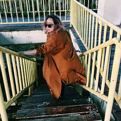 High angle view of woman wearing brown coat on staircase