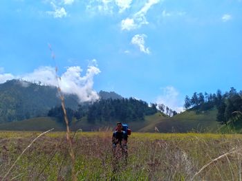 Rear view of person riding bicycle on field