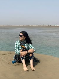 Portrait of woman sitting at beach