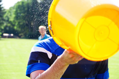 Man holding bucket in lawn