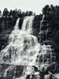 Scenic view of waterfall against sky