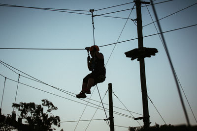 Low angle view of man photographing against sky