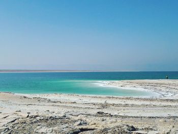 Scenic view of beach against clear blue sky