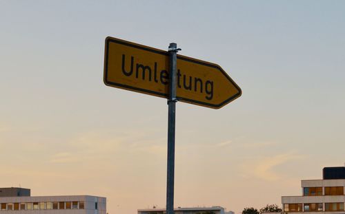 Low angle view of road sign against sky