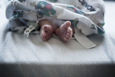 Low section of baby sleeping on bed