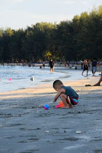 Rear view of people enjoying at beach