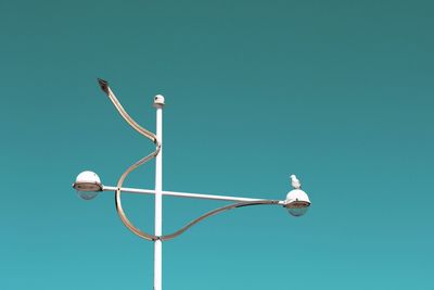 Low angle view of street light against blue sky