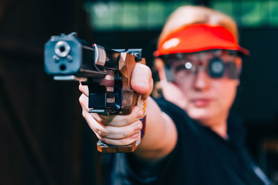 Close-up of woman aiming gun 