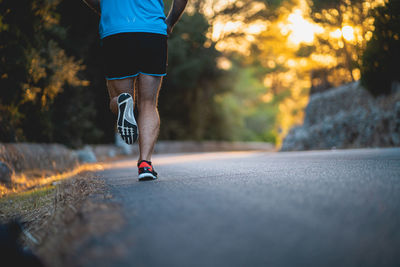 Low section of person running on road