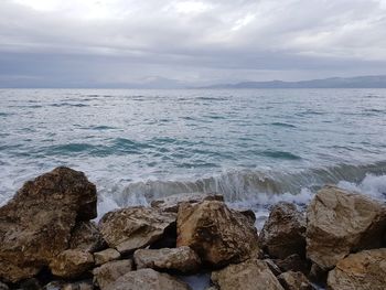 Scenic view of rocks in sea against sky