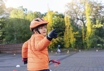 Rear view of boy riding bicycle in park