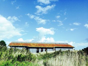 Houses on field against blue sky