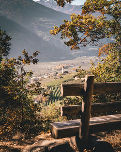 Empty bench in park against sky