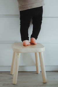 A child small girl stands backwards near white commode