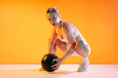 Low section of young woman exercising in gym