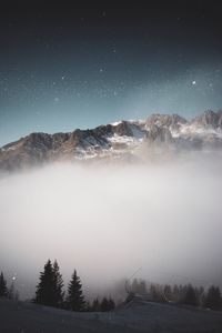 Scenic view of snow covered mountains against sky at night