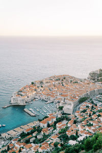 High angle view of townscape by sea against clear sky