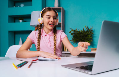 Smiling girl learning on laptop