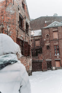 Portrait of person outside house in city during winter