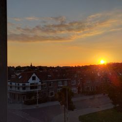 Buildings in city against sky during sunset