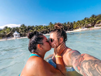 Side view of couple kissing in sea