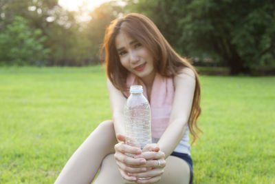 Woman sitting on field at park