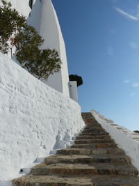 Low angle view of staircase amidst buildings against sky