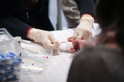 Midsection of female doctor removing patient blood in hospital