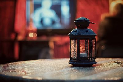 Close-up of lantern on wet table