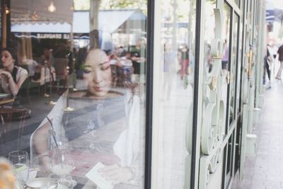 Woman looking at menu while sitting in restaurant