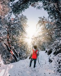 Rear view of man on snow covered field against sky