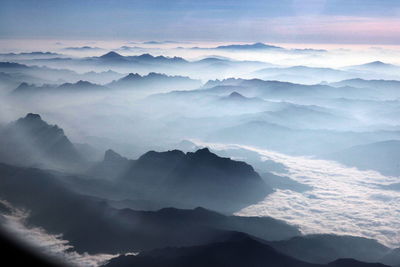 Aerial view of mountain range against cloudy sky