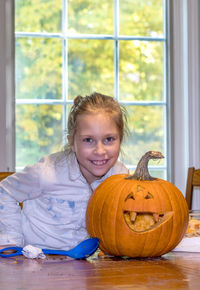 A happy little girl proudly shows off her halloween pumpkin