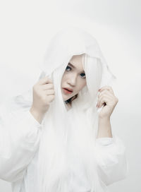 Portrait of young woman against white background