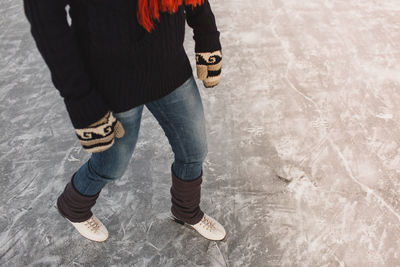 Low section of woman ice-skating on frozen lake