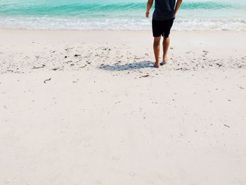 Low section of woman standing on beach