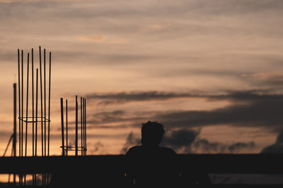 Rear view of silhouette man against orange sky