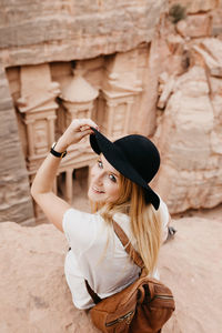 Portrait of young woman wearing hat standing outdoors