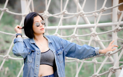 Woman standing by rope at park