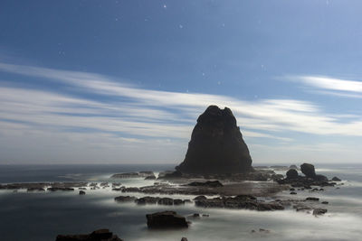 Rocks on sea shore against sky