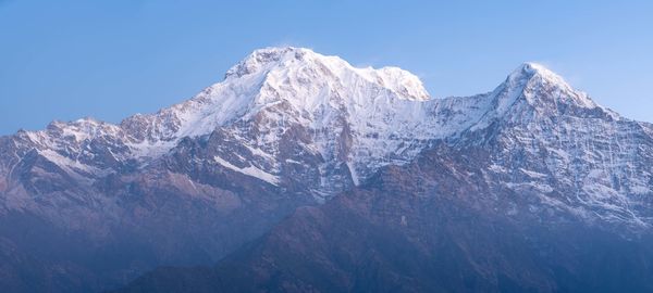 Scenic view of snowcapped mountains against clear sky