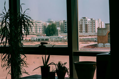 Buildings against sky seen through glass window