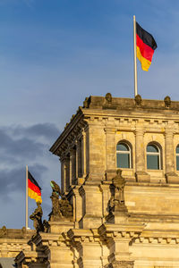 Low angle view of flag on building against sky