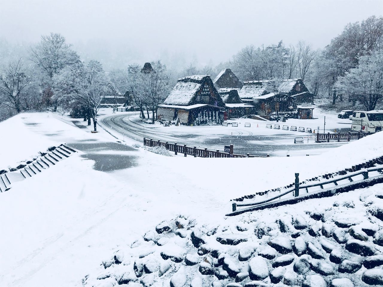 SNOW COVERED FIELD BY HOUSE