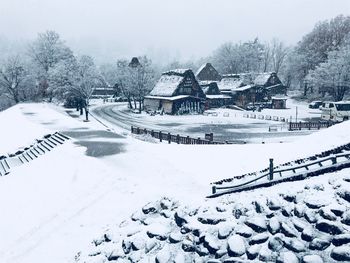 Snow covered field by building