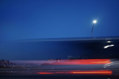 Light trails on street against sky at night