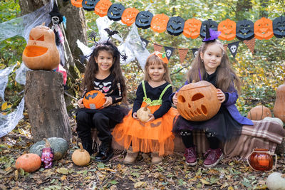 Happy kids in halloween costumes having fun in halloween decorations outdoor