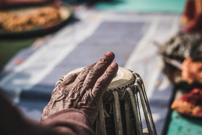 Close-up of hand holding leaf against blurred background