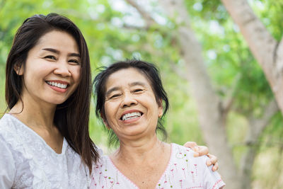 Happy asian family old mother and young daughter hugging each others in a park