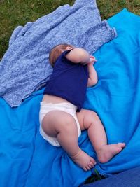 High angle view of baby boy lying on picnic blanket
